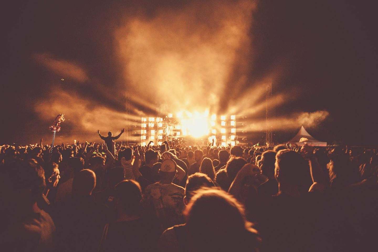 A crowd at a live event under stage lights